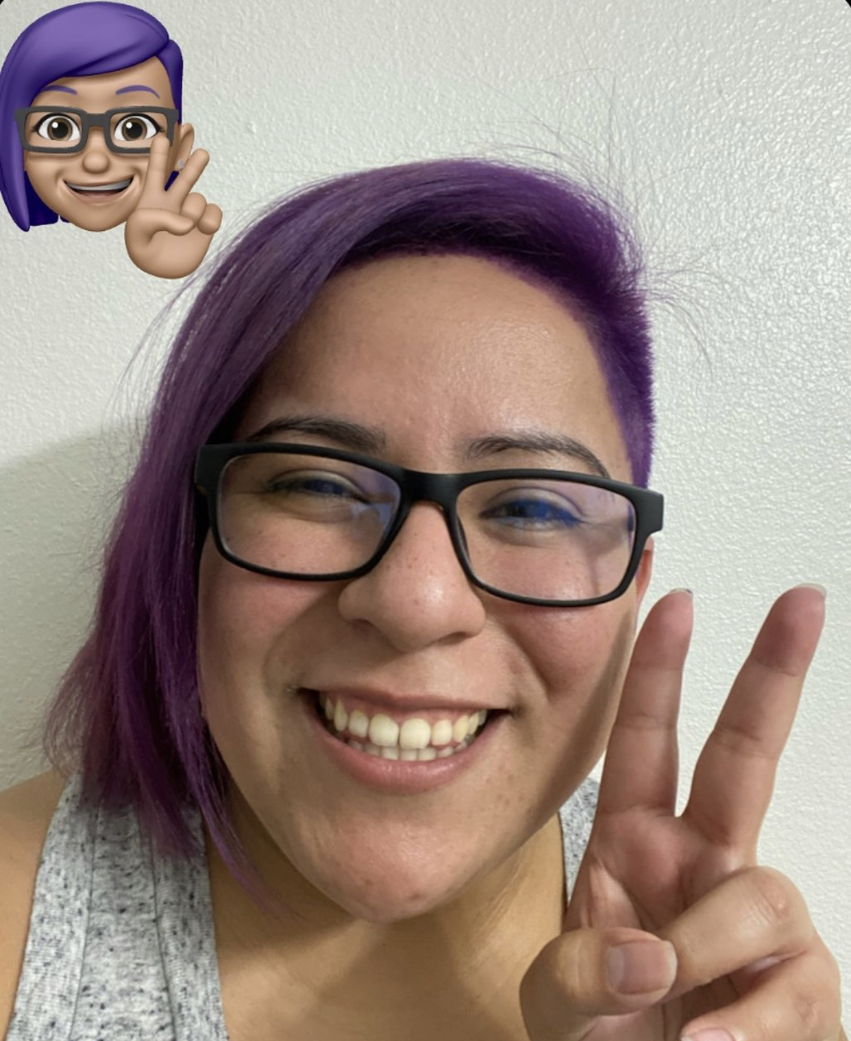 picture of developer with purple hair doing the peace sign
